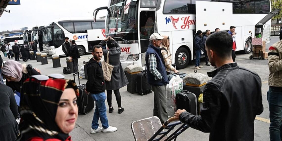 Otogarda yolcu alıp indiren otobüsler ve yolcular